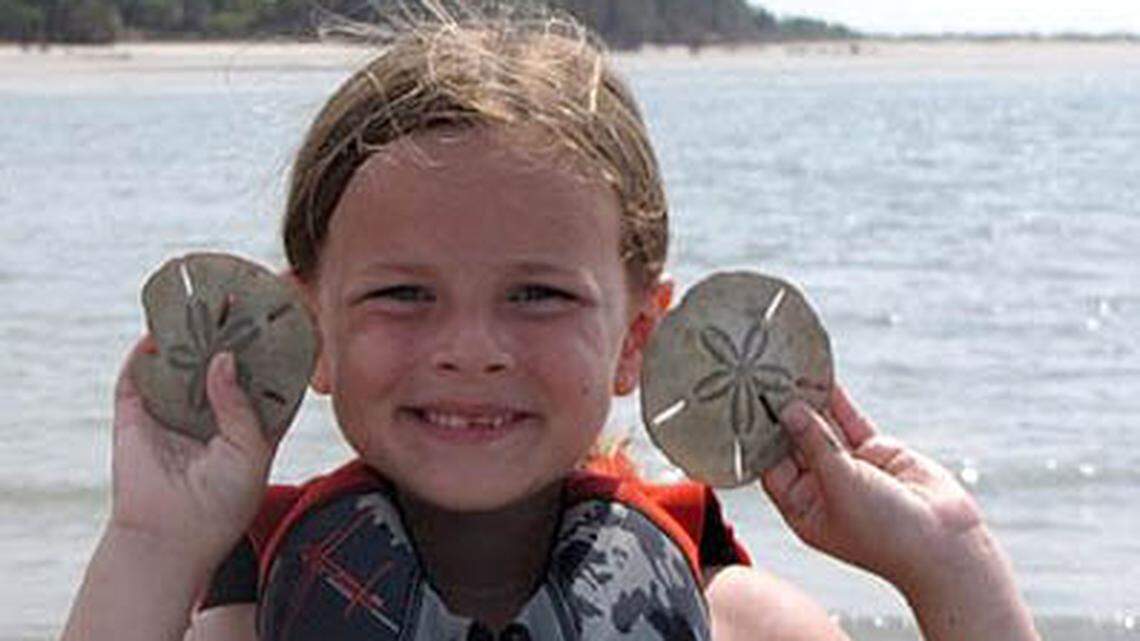 Gracie Packard, 6, holds up sand dollars she found in the area. Sand dollars are living creatures. Biologists recommend that people return them to the water. However, the creatures’  skeletons, which turn white when exposed to the elements, are fair game as keepsakes. Photo by R.C. Van Essendelft of Beaufort.