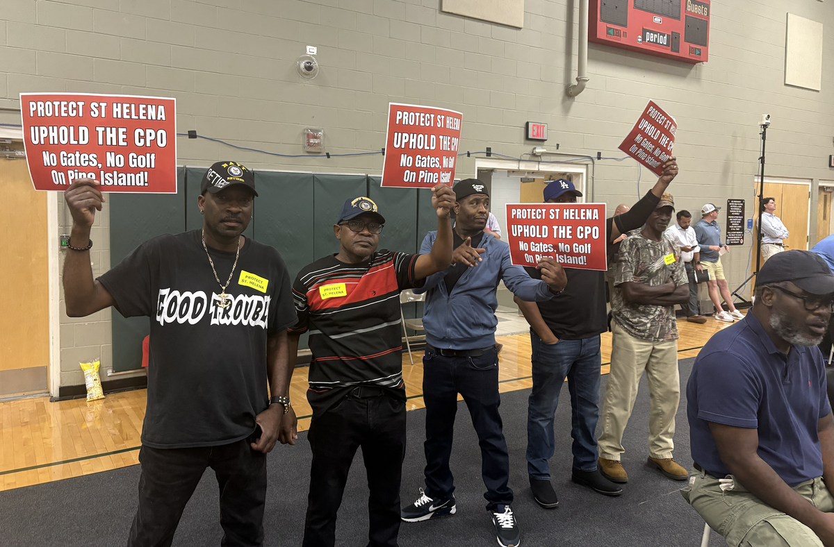 On Monday night, several men held signs asking the Beaufort County Council to uphold the Cultural Protective Overlay on St. Helena Island at the back of the Burton Wells gymnasium.