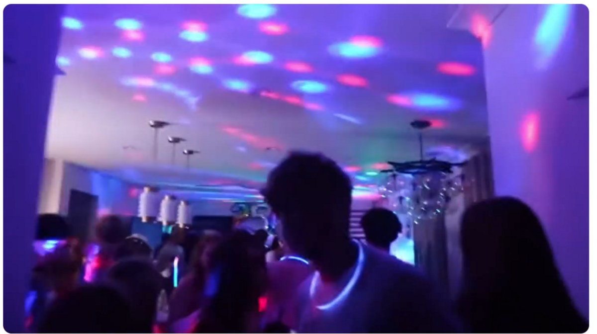 A screenshot of a video shown to members of the public at a Thursday town council meeting shows people attending a house party with neon lights and glow necklaces.