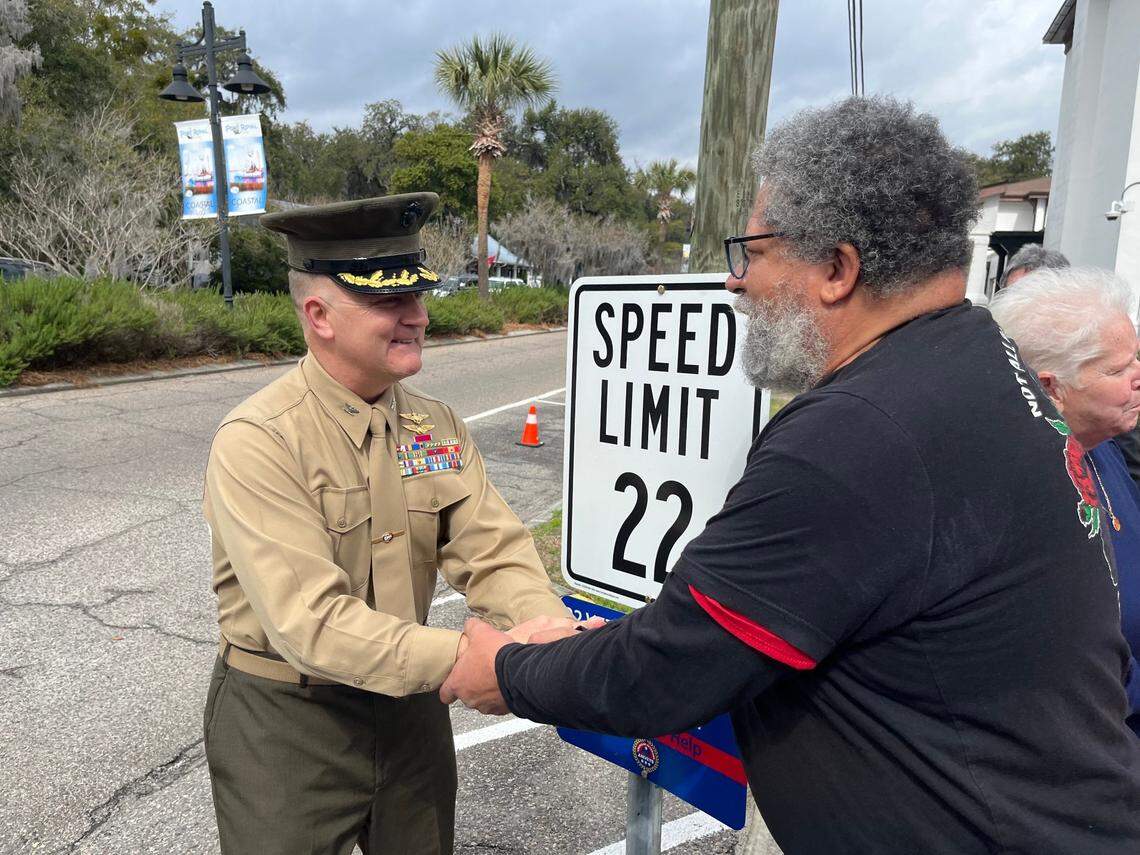 Col. Mark Bortnem, commanding officer of Marine Corps Air Station Beaufort, and John Norman greet each other at a ceremony unveiling 22 mph speed limit signs in Port Royal Friday. The 22 figure was chosen because it represents the number of veterans who kill themselves each day in the United States.