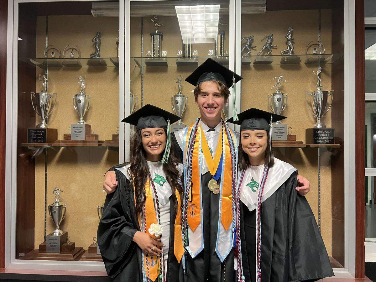 August Rios surrounded with friends Nathalie Mejia-Esquivel (left) and Adriana Campos (right) at Bluffton High School graduation in 2022.