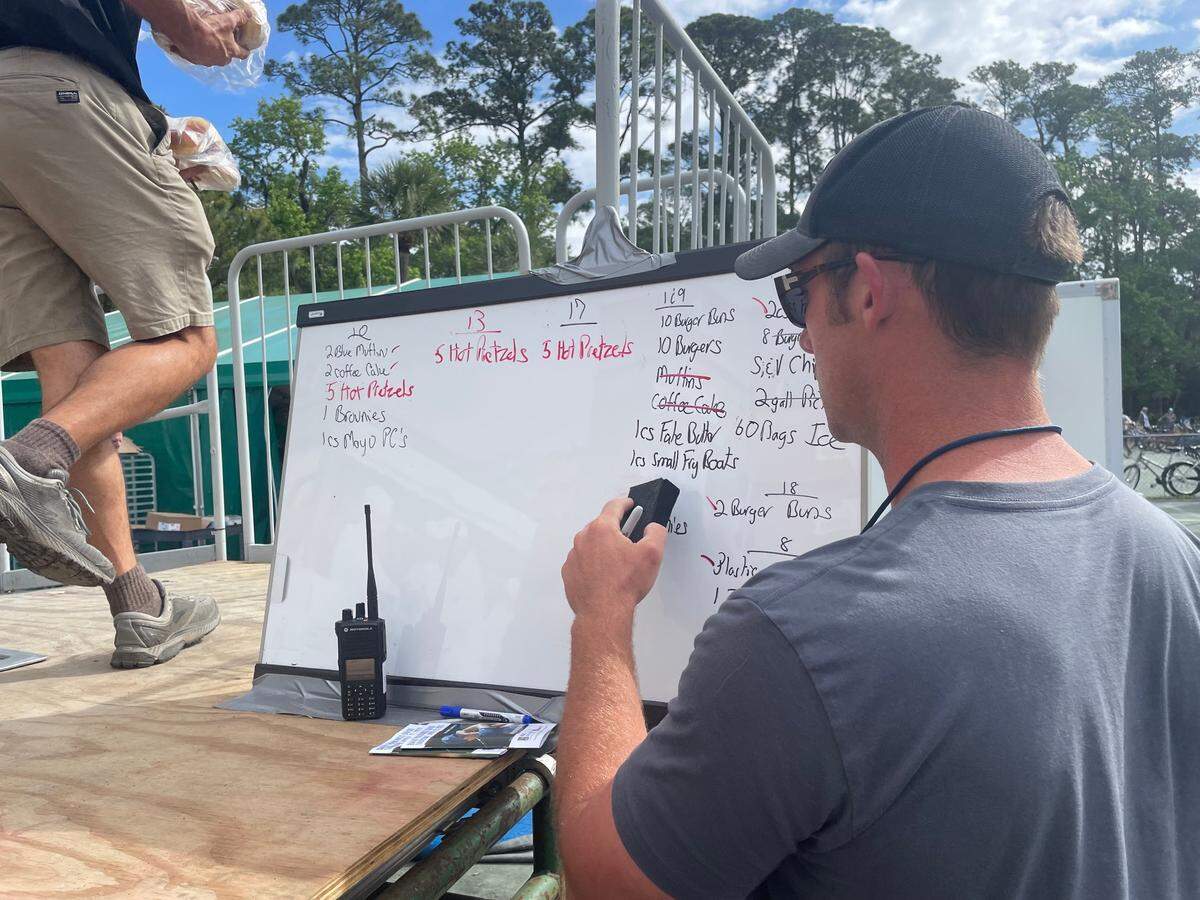 SERG employee Alex Newton tallies how many boxes of food items that each concession stand needs on a white board.