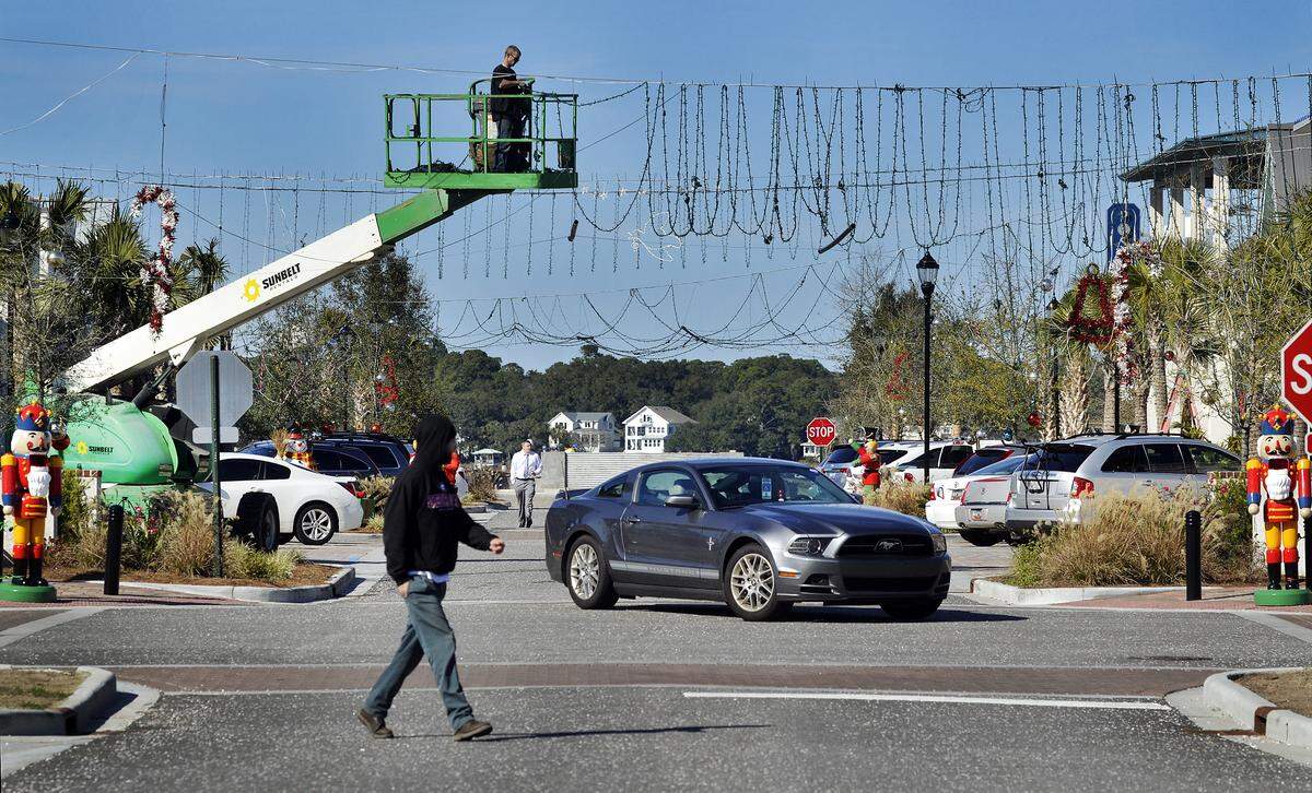 Theophil Syslo, Staff photo Christopher Cauthan, worker for Charleston Decor, removes Christmas lights hanging over Shelter Cove Lane at the Shelter Cove Towne Centre while using a man lift straight boom truck on January 5, 2015.