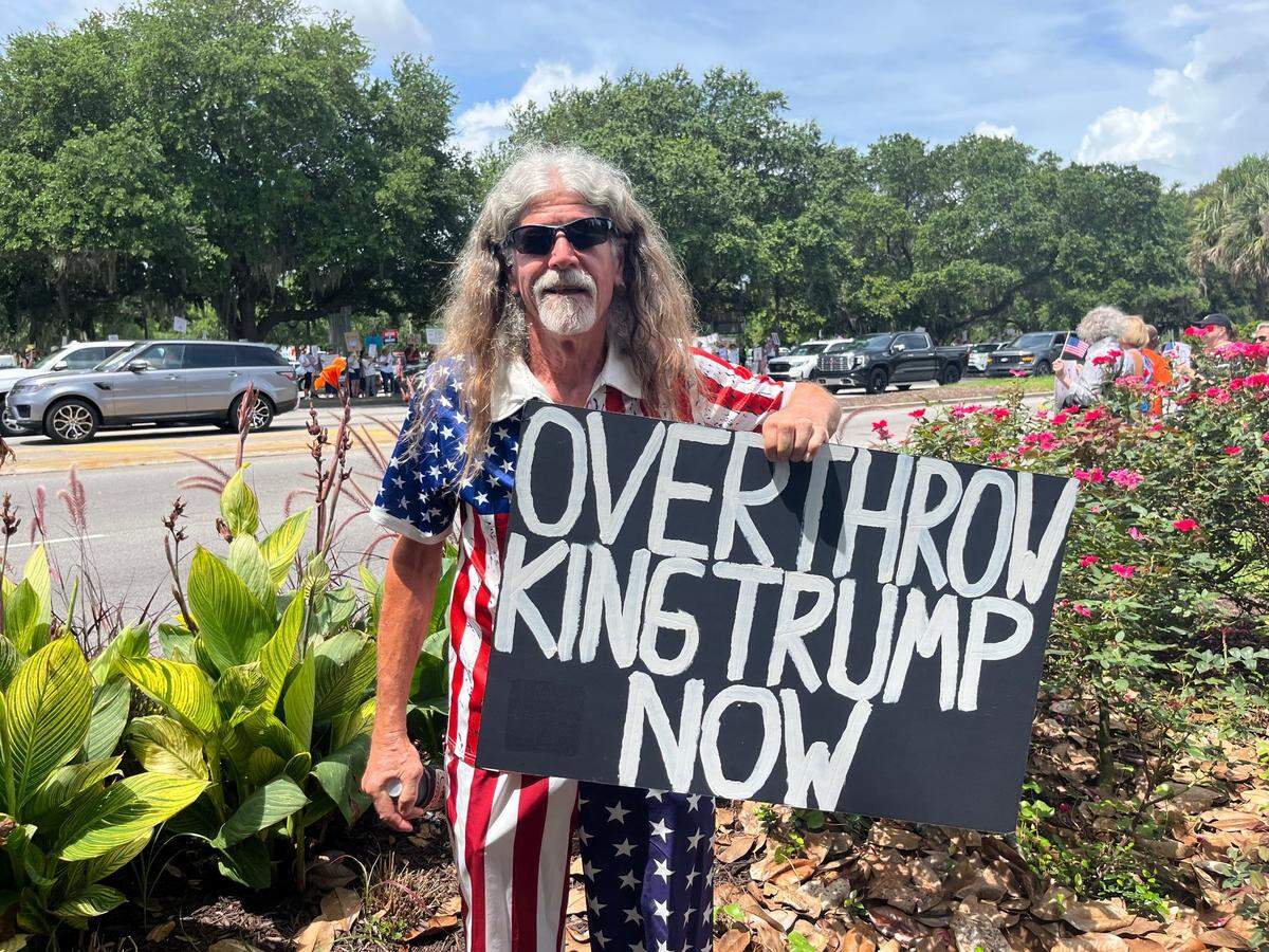 Michael Dixon, 70, dressed like an American flag, arrived with a sign that said, “Overthrow King Trump Now.”