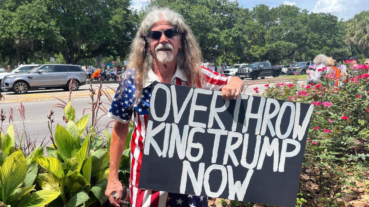 Michael Dixon, 70, dressed like an American flag, arrived with a sign that said, “Overthrow King Trump Now.”