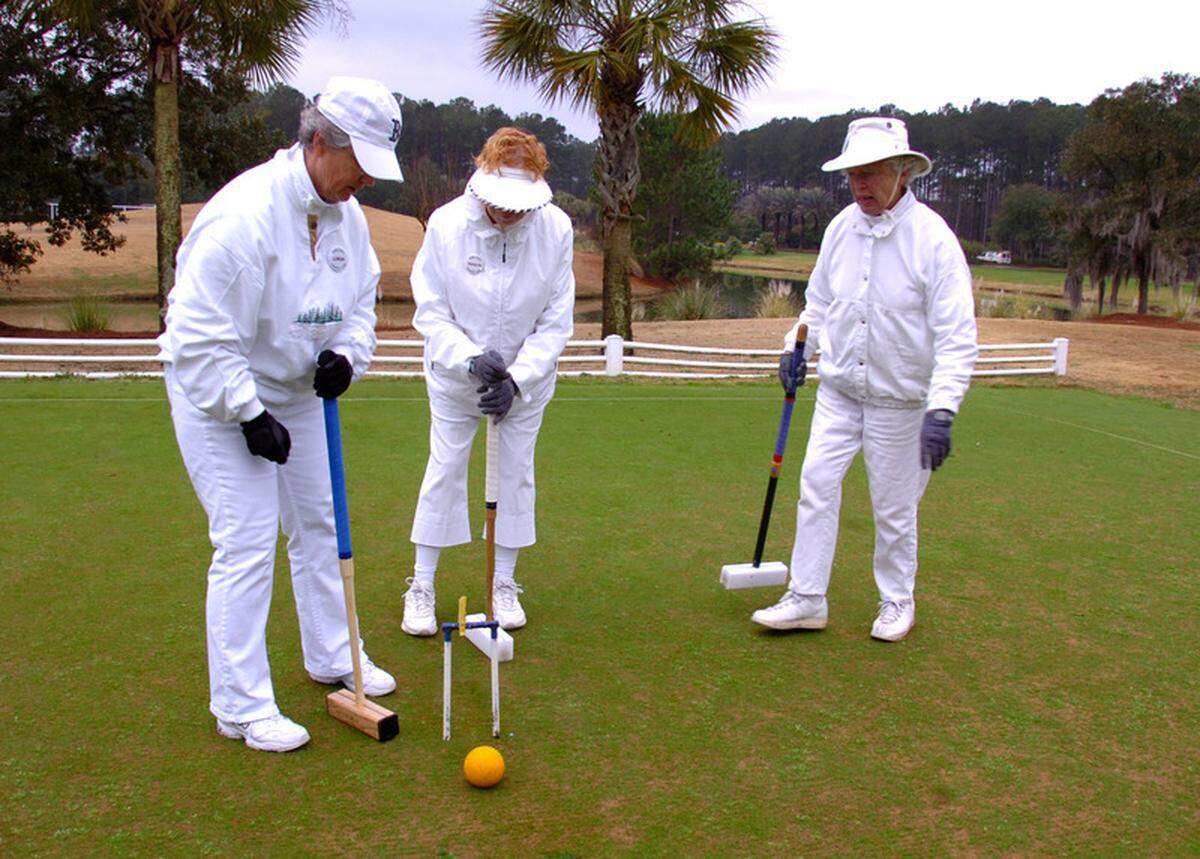 Marilyn Long, center, and Sue Cave, right, watch as Linda Akey plays her turn during a game of croquet with the Sun City Croquet Club in this file photo.