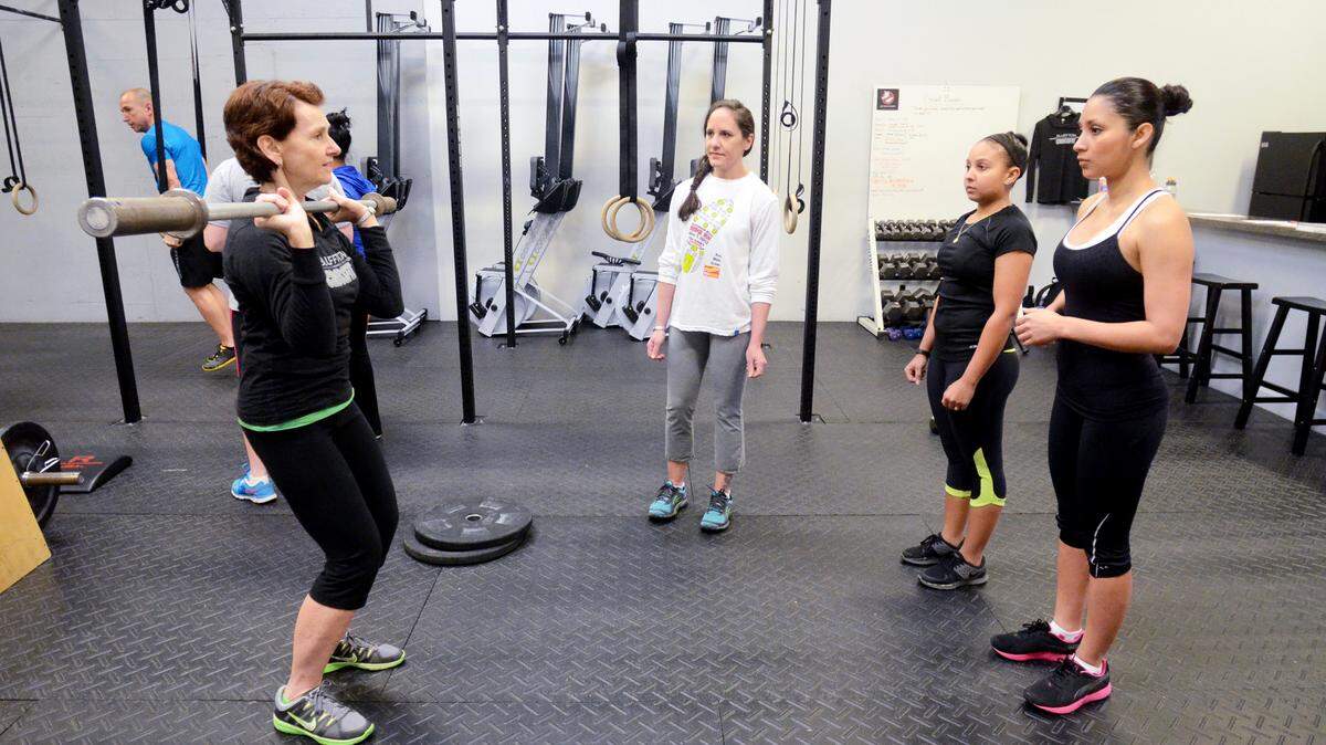 Maureen Tefft, co-owner of Bluffton Crossfit, demonstrates proper weightlifting form while leading an introductory workout class on Saturday morning.