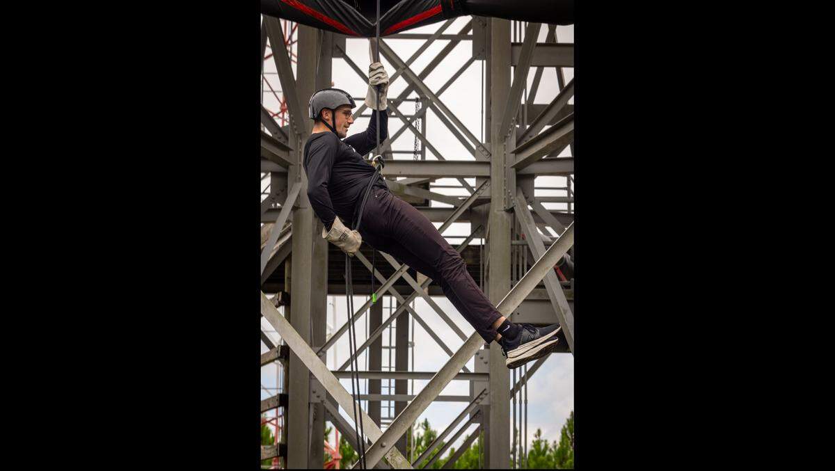 NASCAR driver Austin Cindric rappels down a wall at Marine Corps Recruit Station Parris Island Thursday.