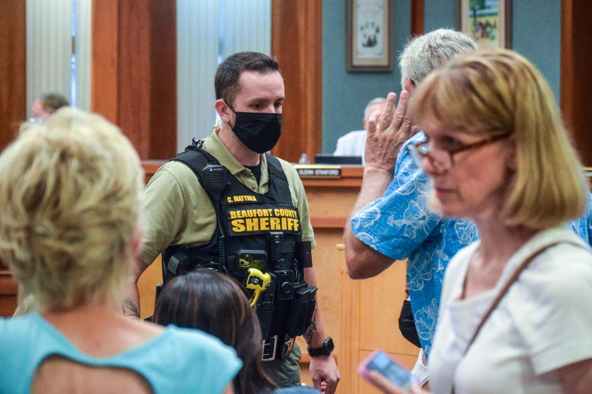A Beaufort County Sheriff’s Office deputy helps control a crowd of anti-mask activists during a Hilton Head Island Town Council meeting on Aug. 17, 2021.