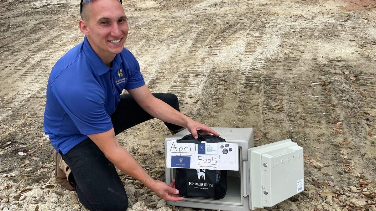 James Merli kneeling in front of the safe that duped hundreds.