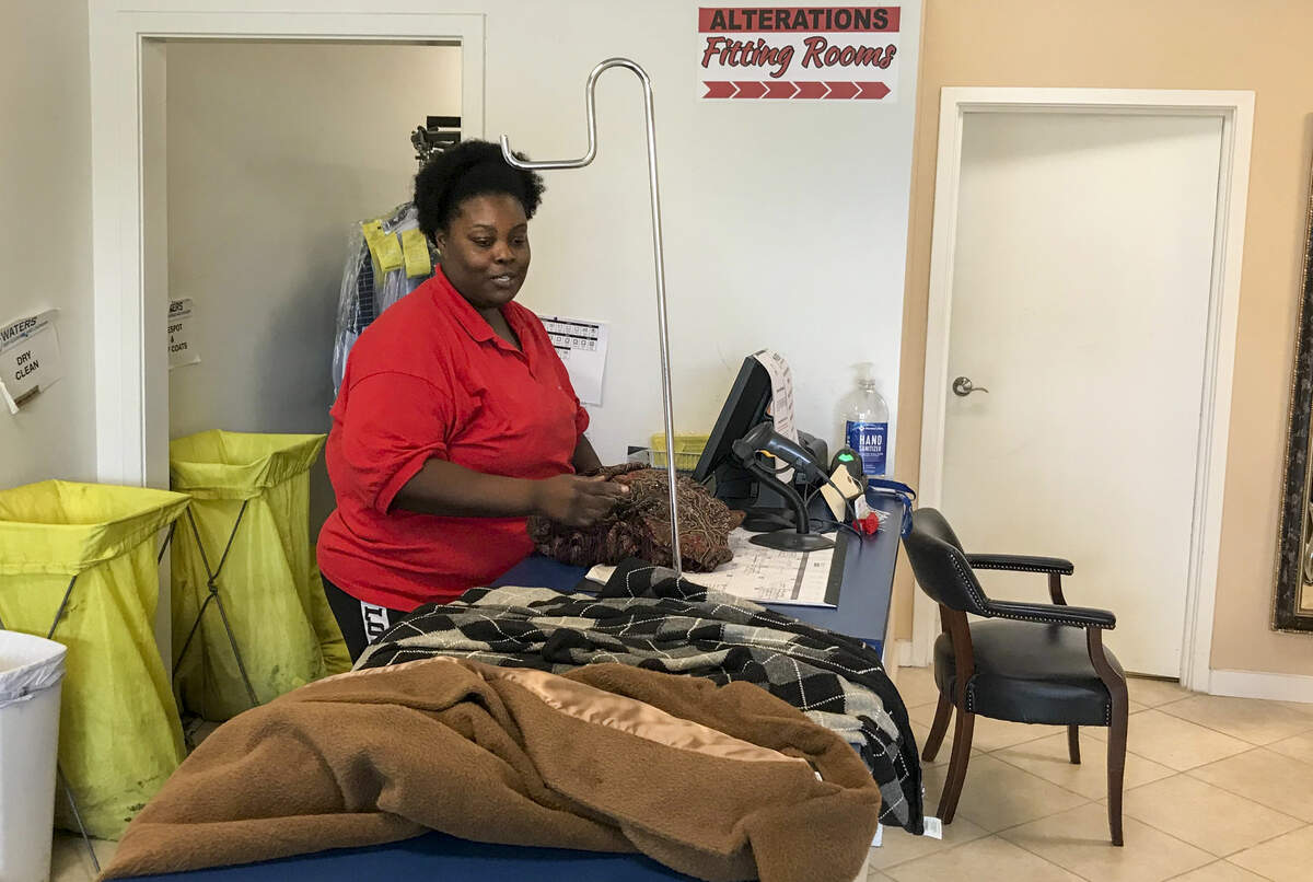 Employee of Waters Dry Cleaners in Bluffton organizes clothes for alterations. Brenda Bacon, manager, says they have had to reduce hours and lay employees off in the wake of the coronavirus.