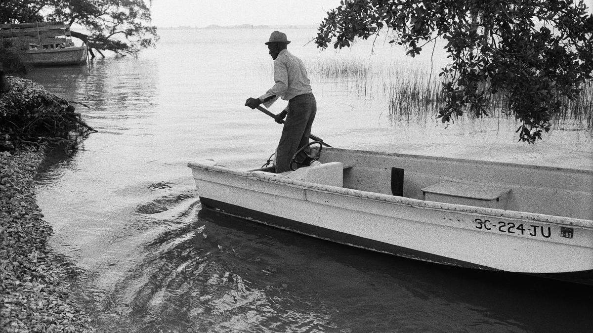 This photo by Jeanne Moutoussamy-Ashe titled âœJake and his Boat Arriving on Daufuskieâ™s Shoreâ is part of photographs donated to the African-American history museum at the Smithsonian. Moutoussamy-Ashe documented Daufuskie Island between 1977 and 1981 and the Gullah/Geechee people who lived there.