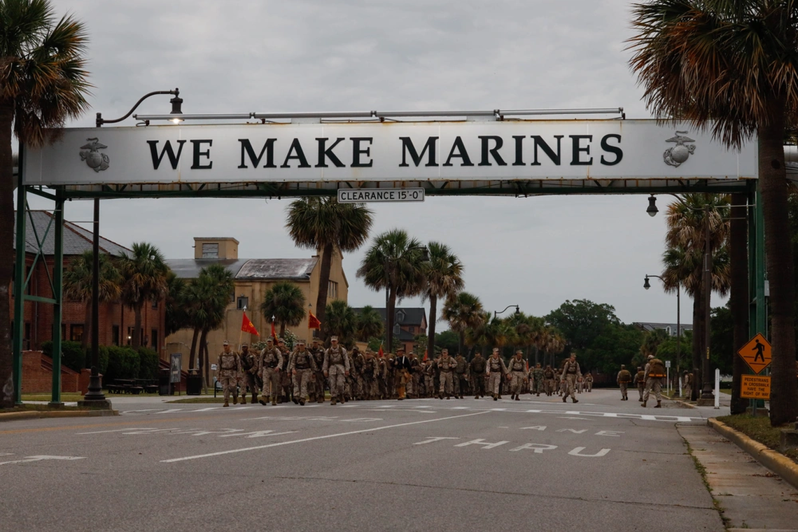 U.S. Marines with Hotel Company, 2nd Recruit Training Battalion, hike under the ‘We Make Marines” sign on Marine Corps Recruit Depot Parris Island, S.C., May 8, 2025. The military training base is under heightened surveillance amid U.S. attacks on Iran, which could impact families of graduating recruits.