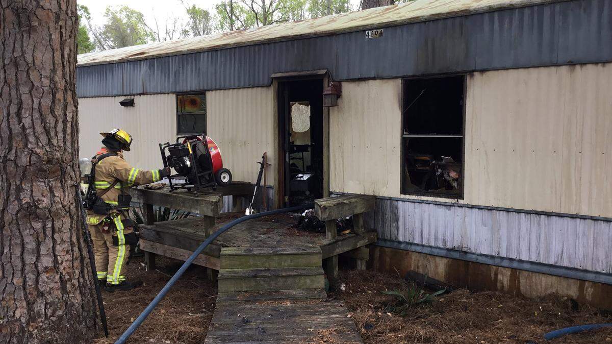 Firefighters work to extinguish a fire at a home on Oak Bluff Court near Laurel Bay on Tuesday. Multiple dogs were killed in the fire, Burton Fire District said.