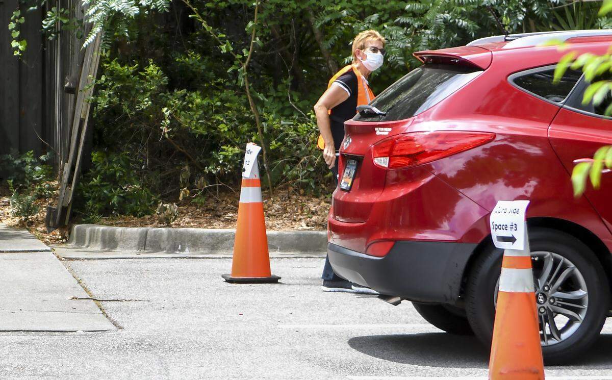 A librarian with the Bluffton Branch of the Beaufort County Public Library asks a driver to pop his trunk on Tuesday, May 19, 2020 in order to provide curbside service. Here’s how it works: After members call their local branch to request an item, customers park in a designated area on weekday hours between 12 p.m. to 4 p.m., and call when they arrive. A librarian will then place the checked-out item in the trunk of the customer’s vehicle.