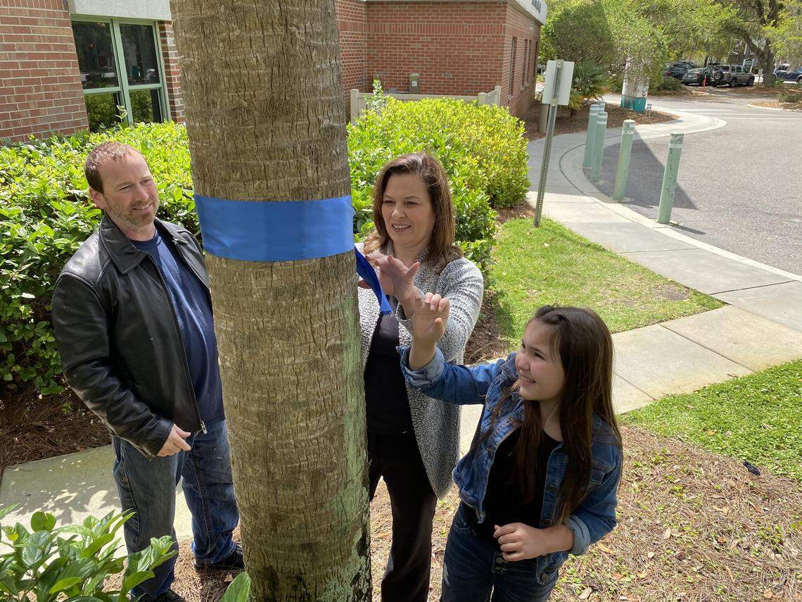 Beaufort residents William and India Dickinson and India’s daughter Sophia Rayne tied blue ribbons on several trees Wednesday at Beaufort Memorial Hospital to honor hospital staff.