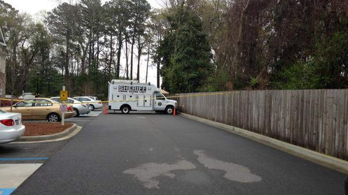 A Beaufort County Sheriff's Office crime scene truck is parked near a fence behind Port Royal Apartments on Grober Hill Road, Beaufort, near where a car was backed through in the early morning hours of March 20, 2015. The male driver of the car was shot and killed, and a woman and child who were passengers were injured and hospitalized.
