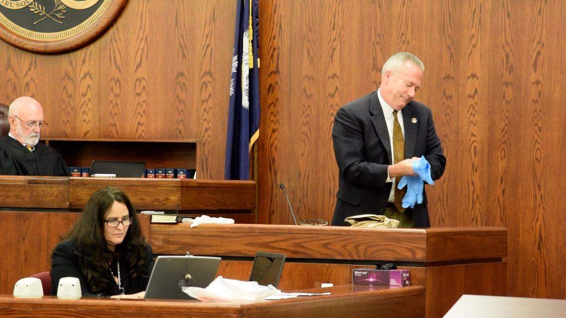 Beaufort County Sheriff’s Office cold case detective Maj. Bob Bromage works to get on latex gloves after two other sets were too small during the State v. Isaiah Gadson Jr.’s trial before handling evidence in a Jan. 5, 1980, murder-rape case.