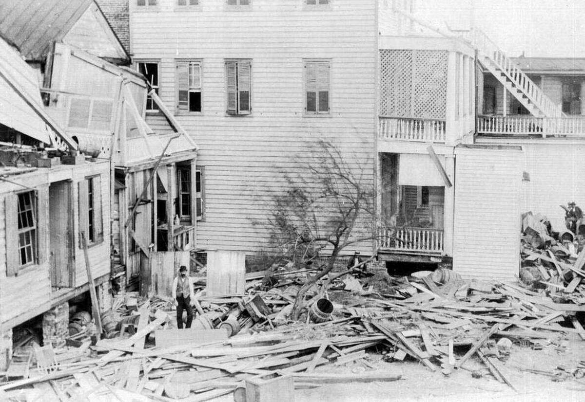 An unidentified man stands amid wreckage from the August 1893 Sea Islands Hurricane that left 30,000 men, women and children homeless on the barrier islands of South Carolina and Georgia. Clara Barton set up headquarters in an old warehouse in Beaufort and remained to oversee the aid effort for nine months.