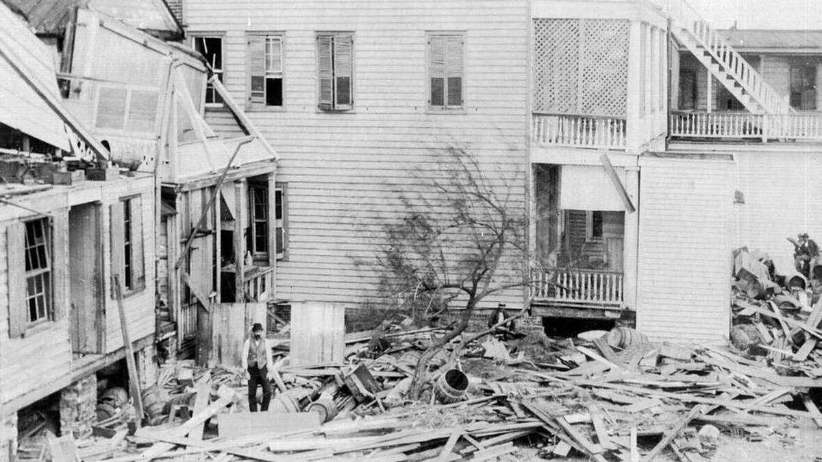 An unidentified man stands amid wreckage from the  August 1893 Sea Islands Hurricane that left 30,000 men, women and  children homeless on the barrier islands of South Carolina and Georgia.  Clara Barton set up headquarters in an old warehouse in Beaufort and  remained to oversee the aid effort for nine months. 