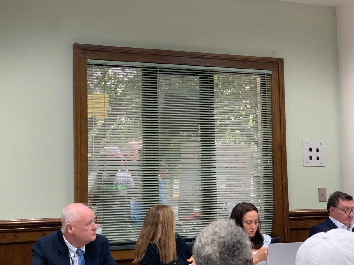 People with signs stand outside the windows of the Beaufort County Council meeting room Monday, when the council was voting on strengthening the St. Helena Island Cultural Protection Overlay. With the meeting room filled to capacity, some residents were not allowed in.