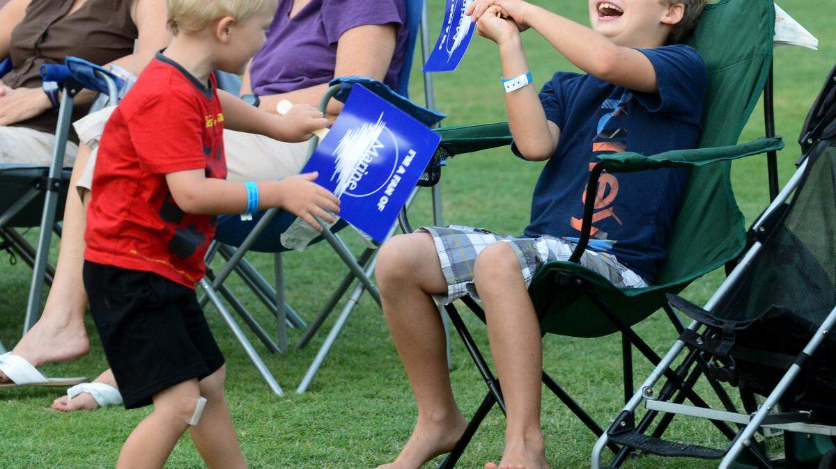 Rusty Walker, 4, and brother Kanaan Walker, 8, swat at each other with their fans to the rhythm of White Chocolate during Time Warp Tuesday at the Beaufort Water Festival. The event was held at Henry C. Chambers Waterfront Park. "They're having fun," said their mother, Erin Walker
