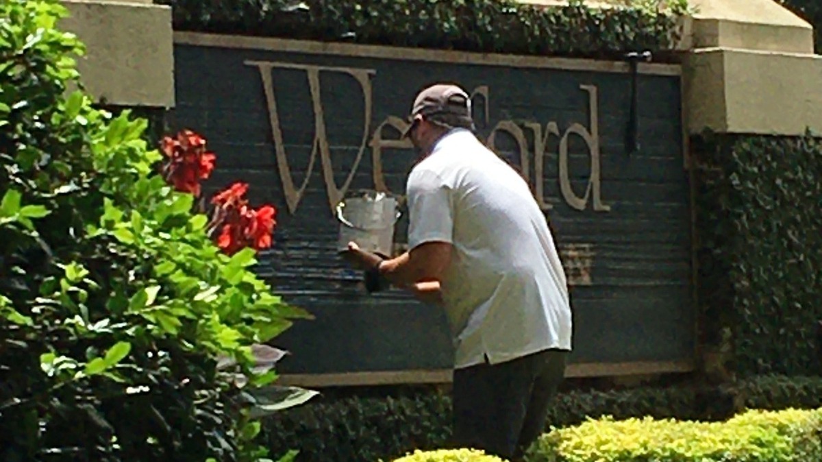 A Wexford employee paints over the word “plantation” on the Hilton Head Island gated community’s sign on July 6, 2020. The community’s board of directors voted to take the word off marketing materials and signage after activists called the word offensive.