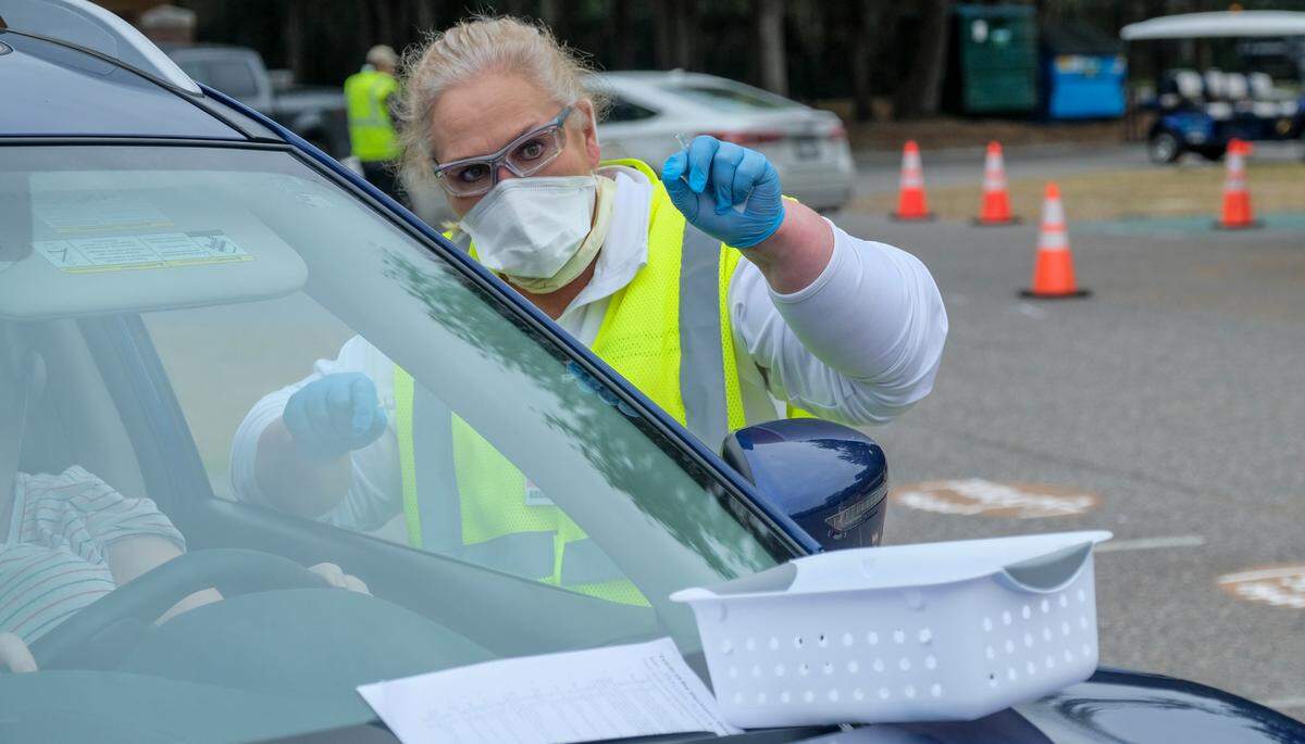 After administering the Pfizer-BioNTech’s vaccine, Dee Ann Sanders, a Registered Nurse in the emergency department at Beaufort Memorial Hospital, instructs a driver on Thursday, Jan. 21, 2021 to pull up to the next station in the parking lot of Beaufort High School’s stadium. Thursday marked the first drive-thru clinic for vaccine administration in Beaufort County.