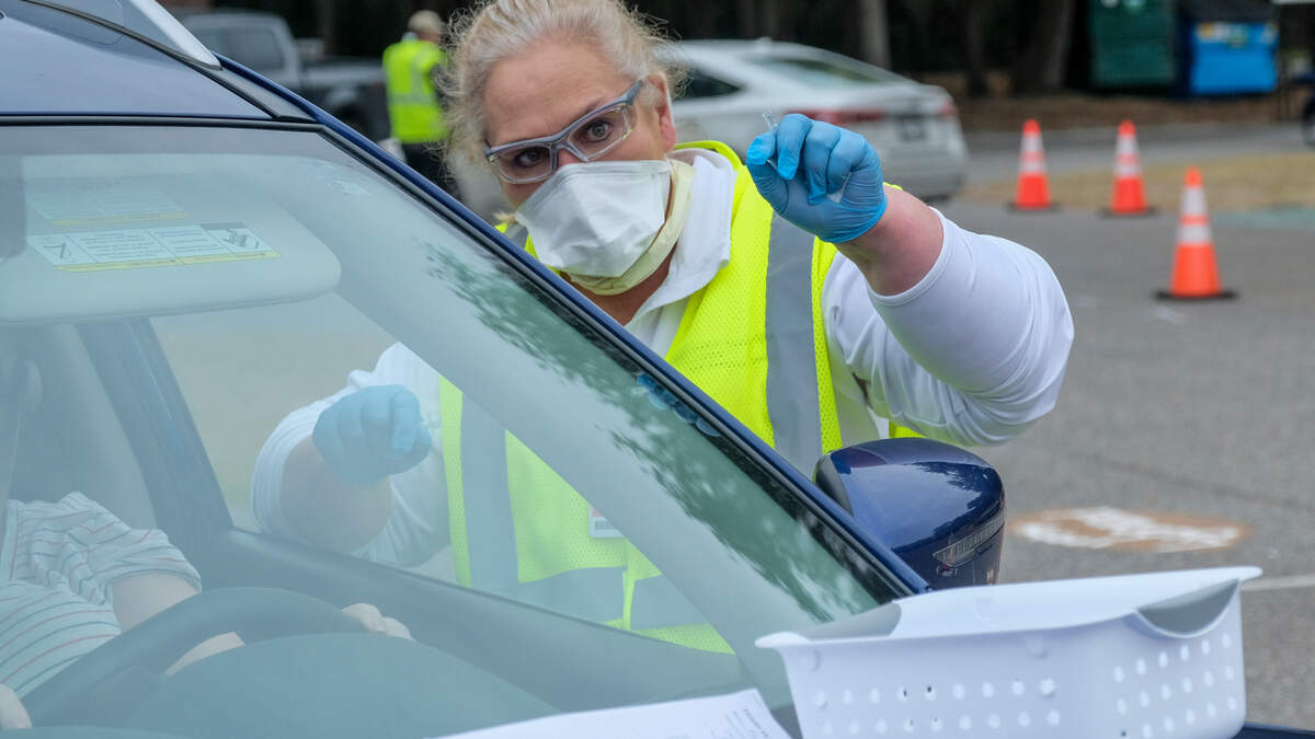 After administering the Pfizer-BioNTech’s vaccine, Dee Ann Sanders, a Registered Nurse in the emergency department at Beaufort Memorial Hospital, instructs a driver on Thursday, Jan. 21, 2021 to pull up to the next station in the parking lot of Beaufort High School’s stadium. Thursday marked the first drive-thru clinic for vaccine administration in Beaufort County.