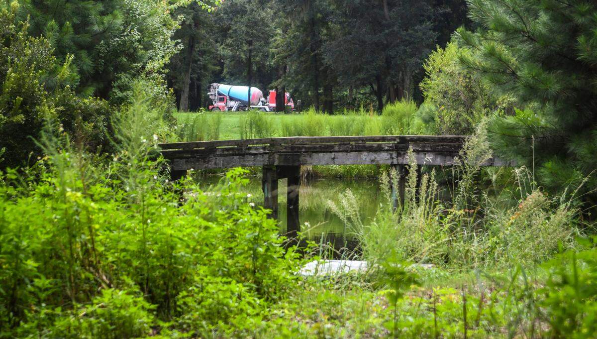 A cement truck makes its way along U.S. 278 as a golf cart bridge can be seen through the overgrown foliage on Town of Hilton Head Island owned land, formerly the Planters Row Golf Course, as seen on Monday, Aug. 22, 2022. The 103-acre property – bounded by U.S. 278, Dillon and Union Cemetery roads – is planned to become a community park.