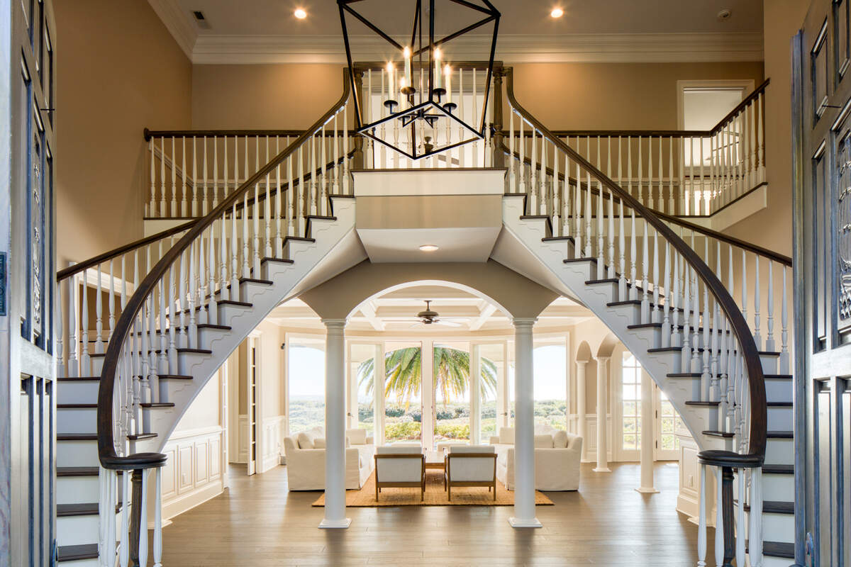 A view of the elaborate double staircase and floor-to-ceiling windows found at 38 Ensis Road on Hilton Head Island, SC.