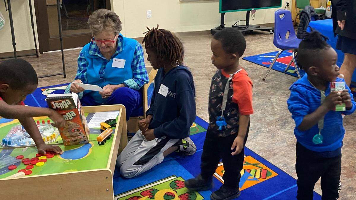A Circles program volunteer sits with a group of children during a Nov. 16 kickoff event for the program’s families. The Circles program aims to fight poverty by encouraging friendships across income strata, which has been shown to have a major impact on lower-income families raising their economic status.