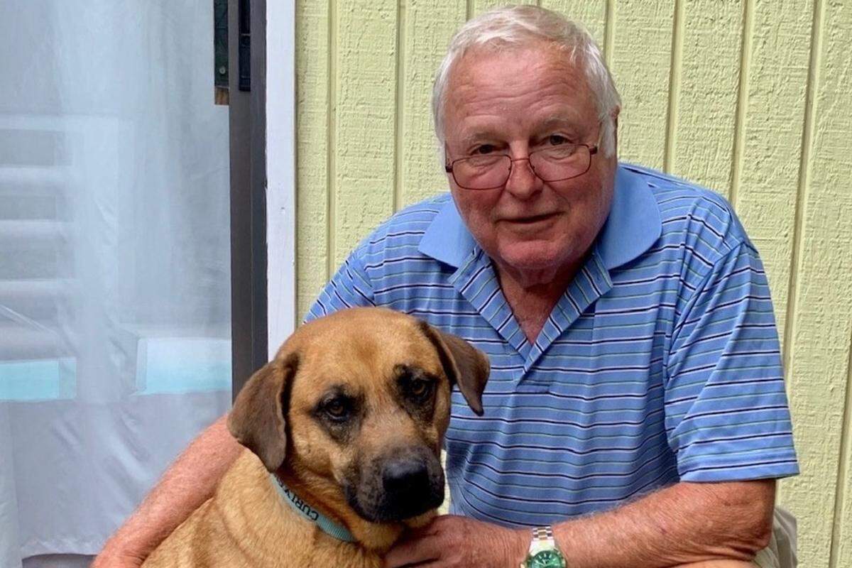 Brian poses with his dog Curly, who woke him up when their home was on fire and saved their lives.