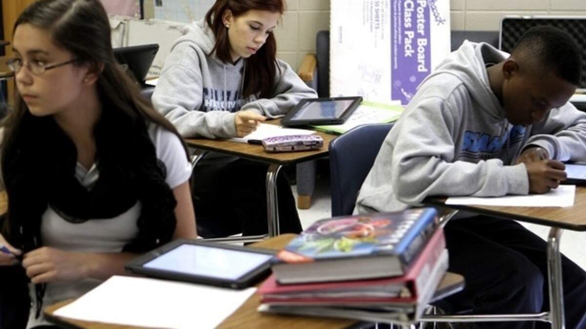 Camille Newton, left, Haley Hancock, middle, and Jestin Morrow use iPads to solve graphing problems in their Algebra I class at Hilton Head Island High School.