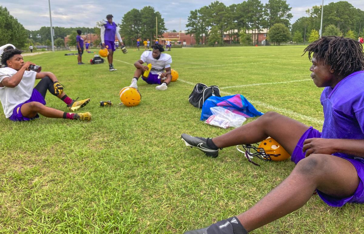 Whale Branch Early College High School football players Joseph Hicks, from left, D’Ante Parker and Ray Pryor sit during a break in practice Tuesday. Players were split into three small groups, each has his own water bottle and pads and other equipment are sanitized as a precaution against spreading coronavirus.