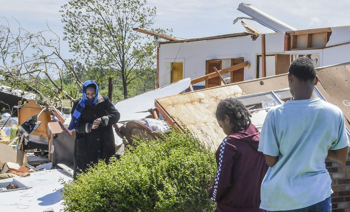 Nora Bright, left, stands next to the headboard of the bed she was sleeping in at her aunt’s home in Lena, South Carolina on Monday, April 13, 2020 after the home was destroyed by a tornado. Her 91-year-old aunt, Alberta Farmer, was sleeping in the next room, the headboard to her bed seen in the background. Both women were not seriously injured.