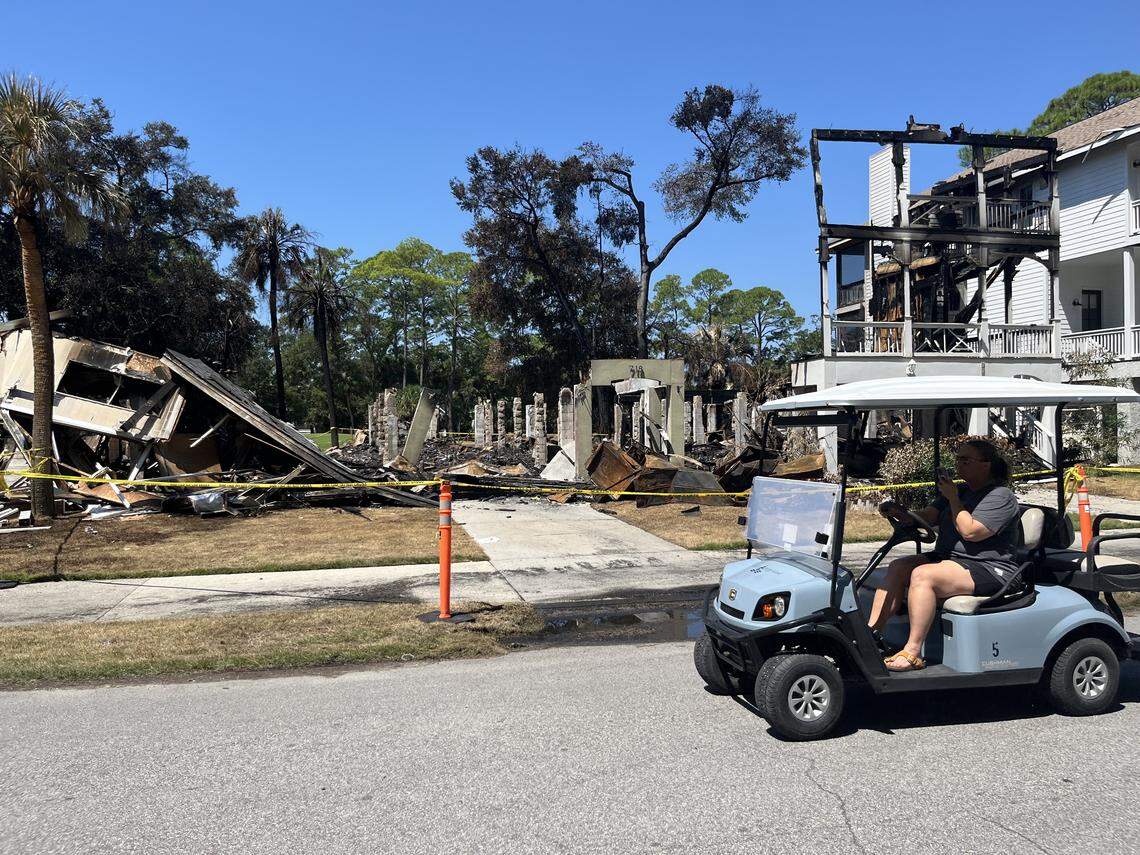 A golf cart driver passes by houses on Bonito Road on Fripp Island Monday. Three houses were destroyed by a Saturday fire, which also claimed the life of a 59-year-old man.