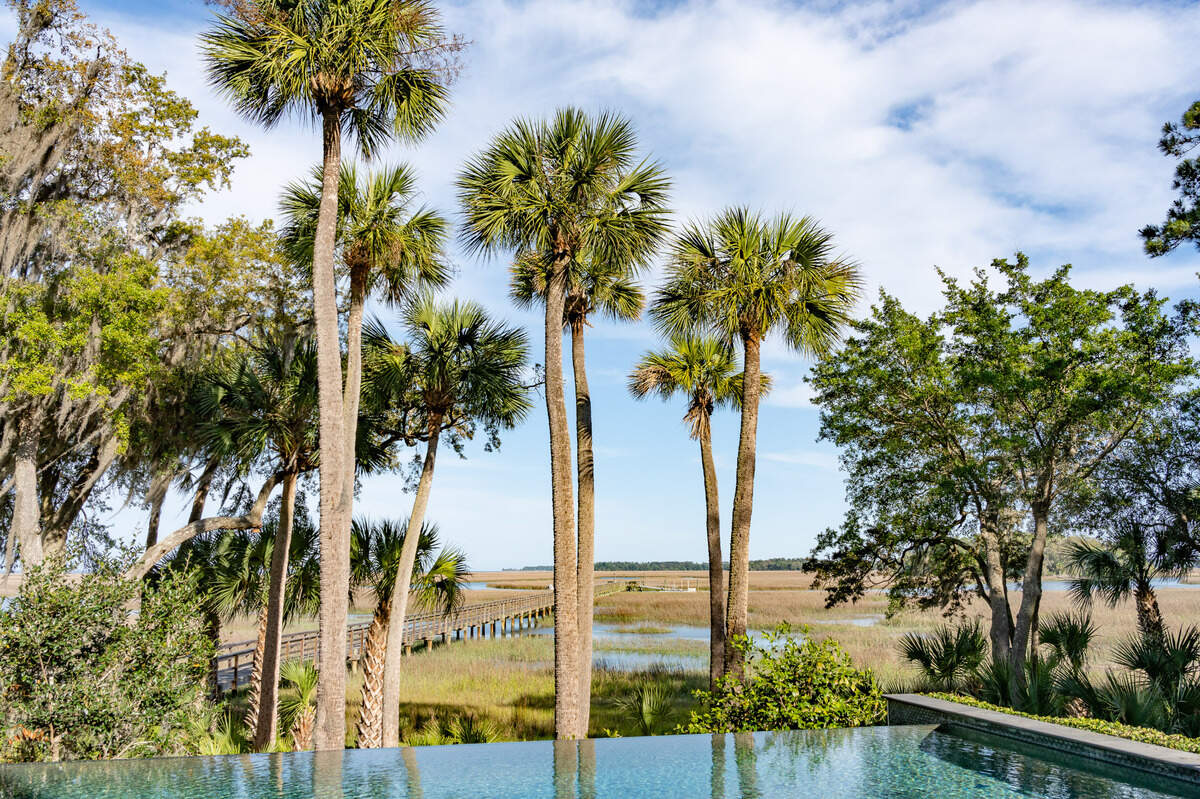 16 Hampton Lane, in Colleton River Club, has an outdoor infinity pool overlooking the deepwater dock and Lowcountry marsh views.