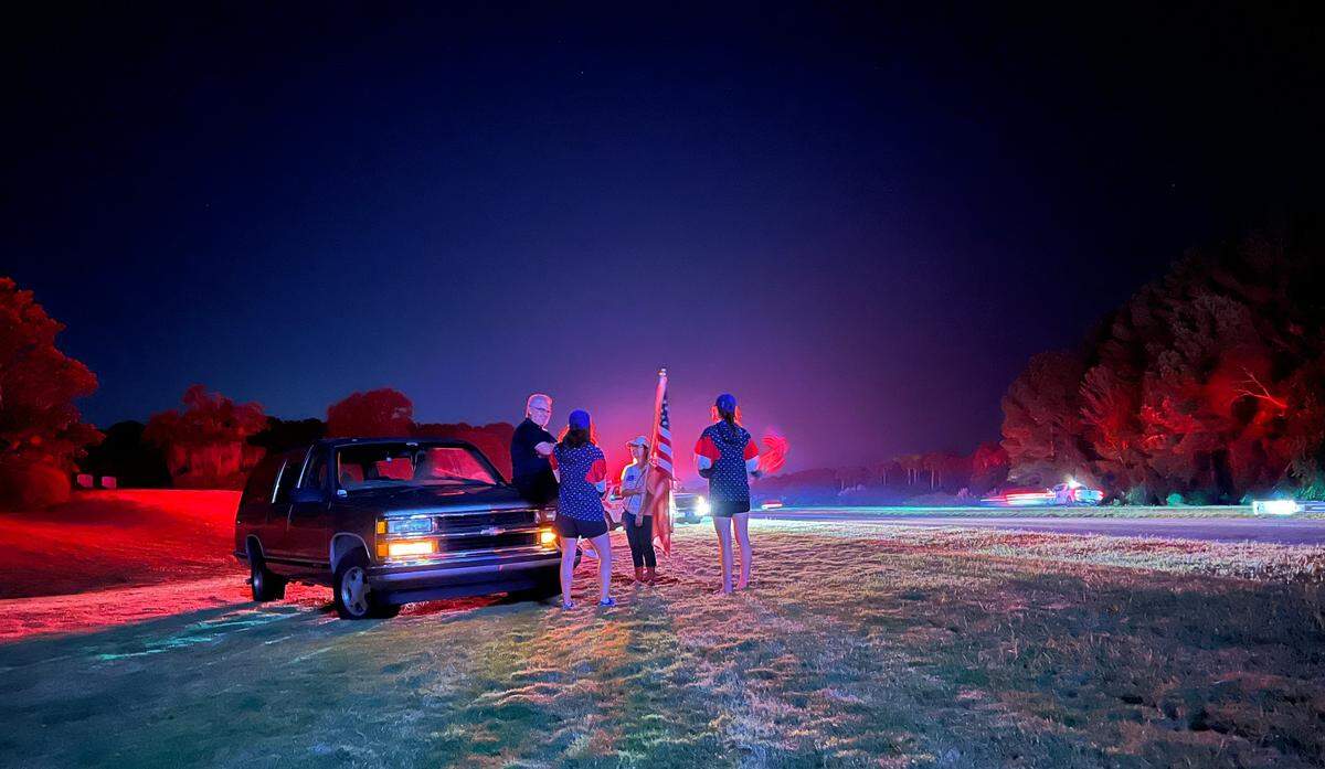 Bluffton residents wait along U.S. 278 for the funeral procession of Lt. Col. Andrew Mettler on Tuesday night.