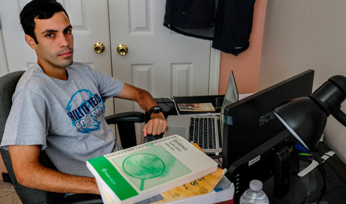 Kebin Lopez, 25, un recipiente de DACA, se siente para un retrato el 22 de abril de 2021 en su dormitorio de infancia en Bluffton, S.C donde asiste virtualmente a clases de la facultad de derecho de la Universidad de Florida.