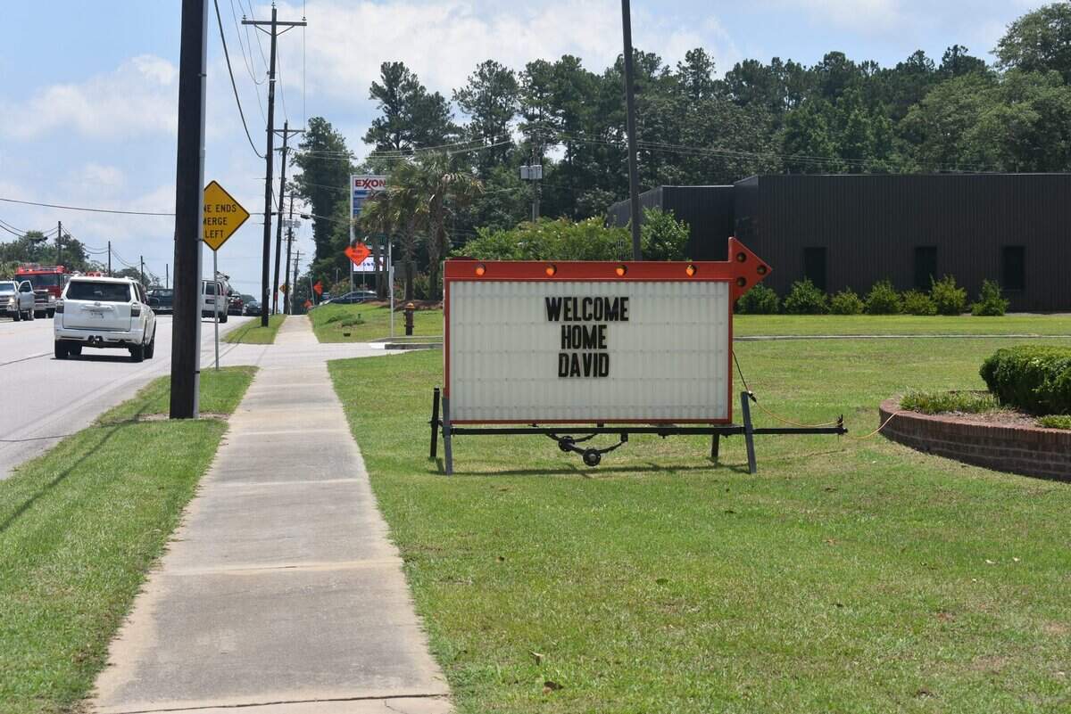 A marque sign reading “Welcome home David” was set up along the path his ambulance took during his last ride.