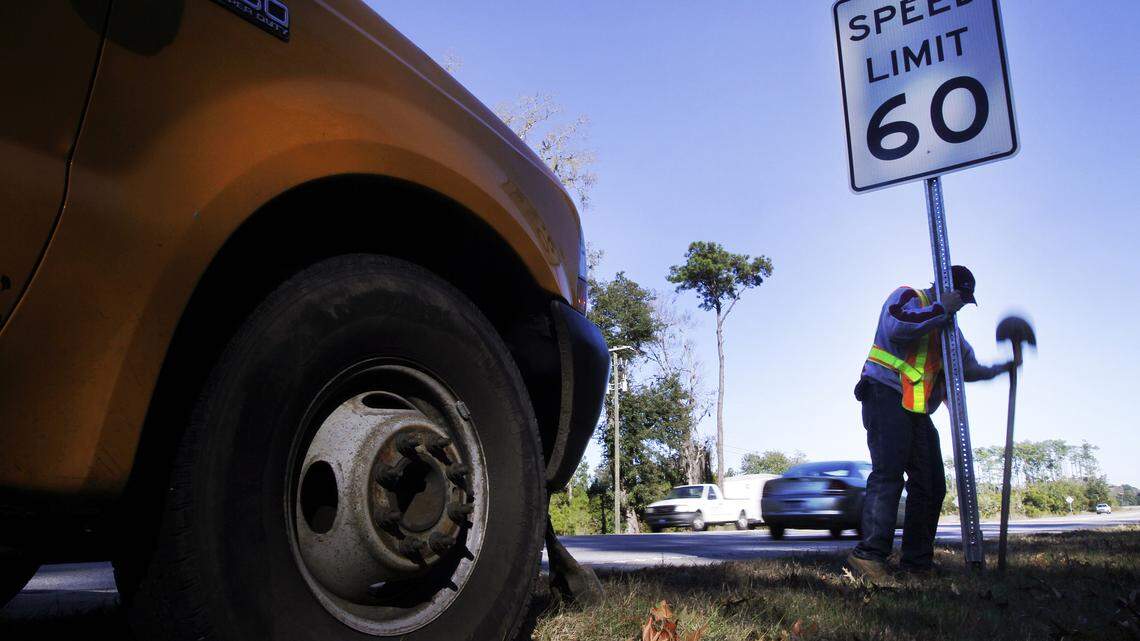SCDOT worker Scott Gregory, right, installs new speed limit signs along Okatie Highway/SC 170 near Snake Road in Okatie on Jan. 8, 2014.  The new signs set a 60 mph speed limit, five miles per hour faster than the previous limit of 55 mph.
