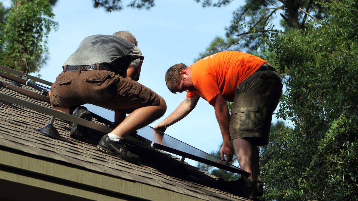 Sam Courtney, project manager with Wind Turbines of South Carolina, LLC., right, and his father Greg Courtney, co-owner of the company, install solar panels on the roof of the home owned by Greg Galvin on Wednesday afternoon in Bluffton.