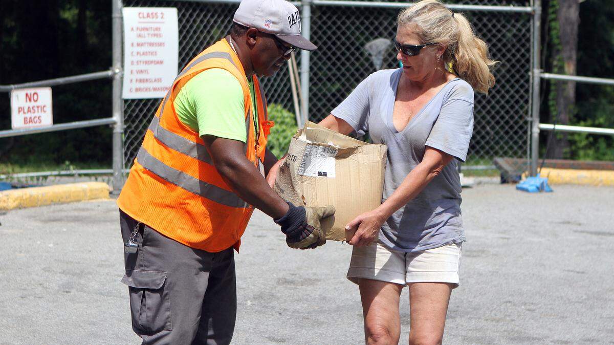 David Frazier, an employee at the Beaufort County Convenience Center on Castle Rock Road, helps Candace Martin of Beaufort unload her trash on Thursday afternoon in Beaufort.