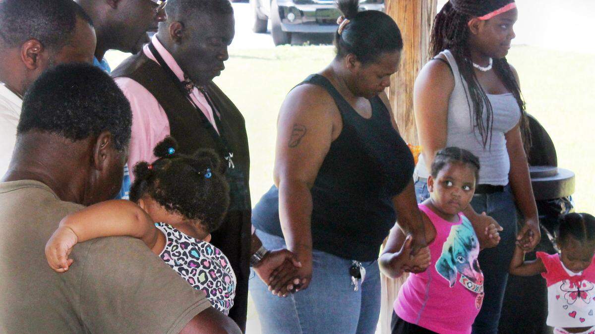 Members of the community join hands and say a prayer on Thursday for the nine victims of Wednesday's Charleston church shooting during a special Prayer in the Park gathering at Ridgeland's Harold Turpin Park. One of the victims of the shooting was Ridgeland's State Sen. Clementa Pinckney.