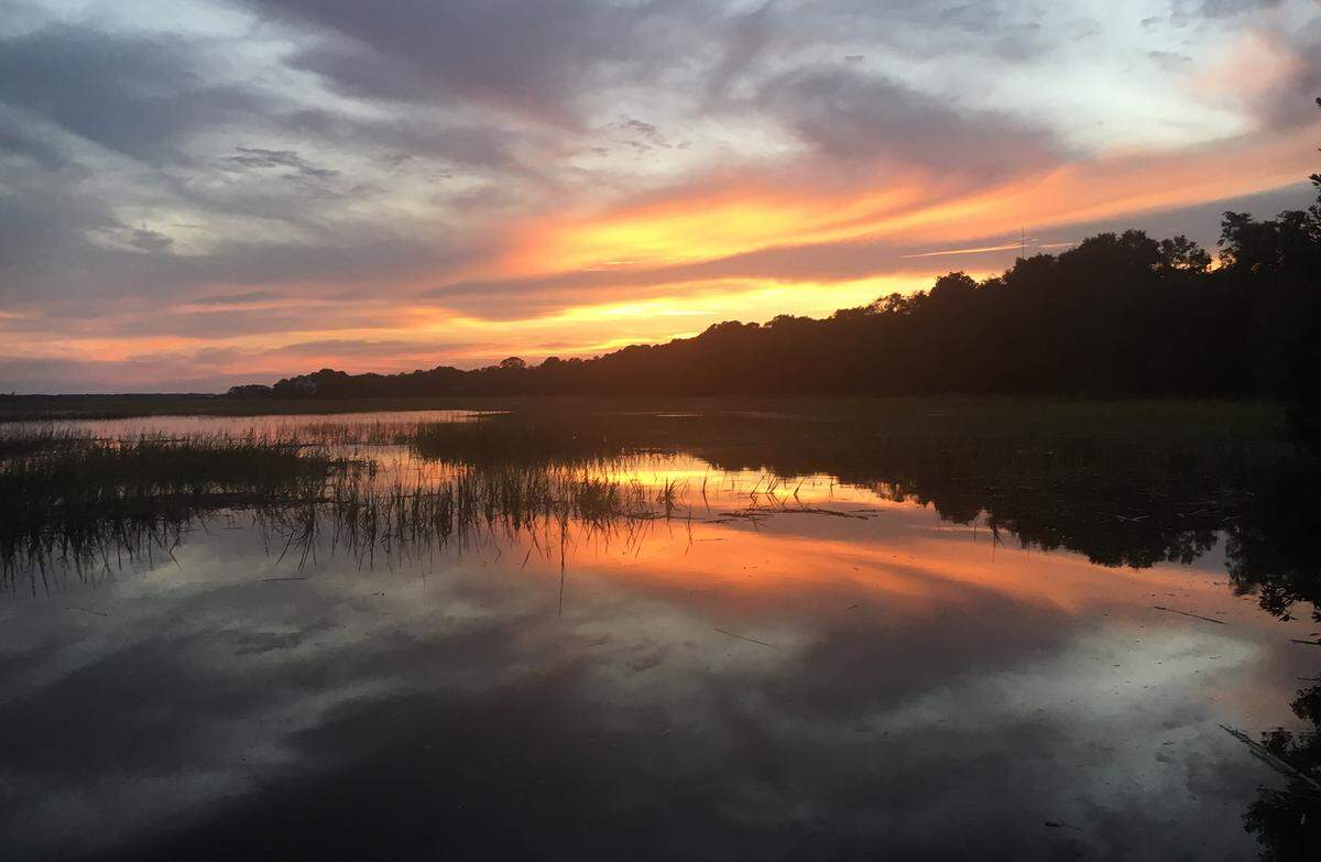 The sun sets over Broad Creek at the Old Oyster Factory restaurant.