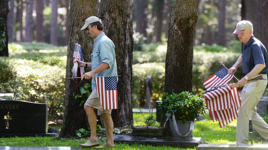 John Marcinowski, left, and Bob Reuter, with the Hilton Head Island Chapter of the Military Officers Association of America, plant flags on veterans' graves in observance of Memorial Day on Thursday at Sea Pines' Six Oaks Cemetery.