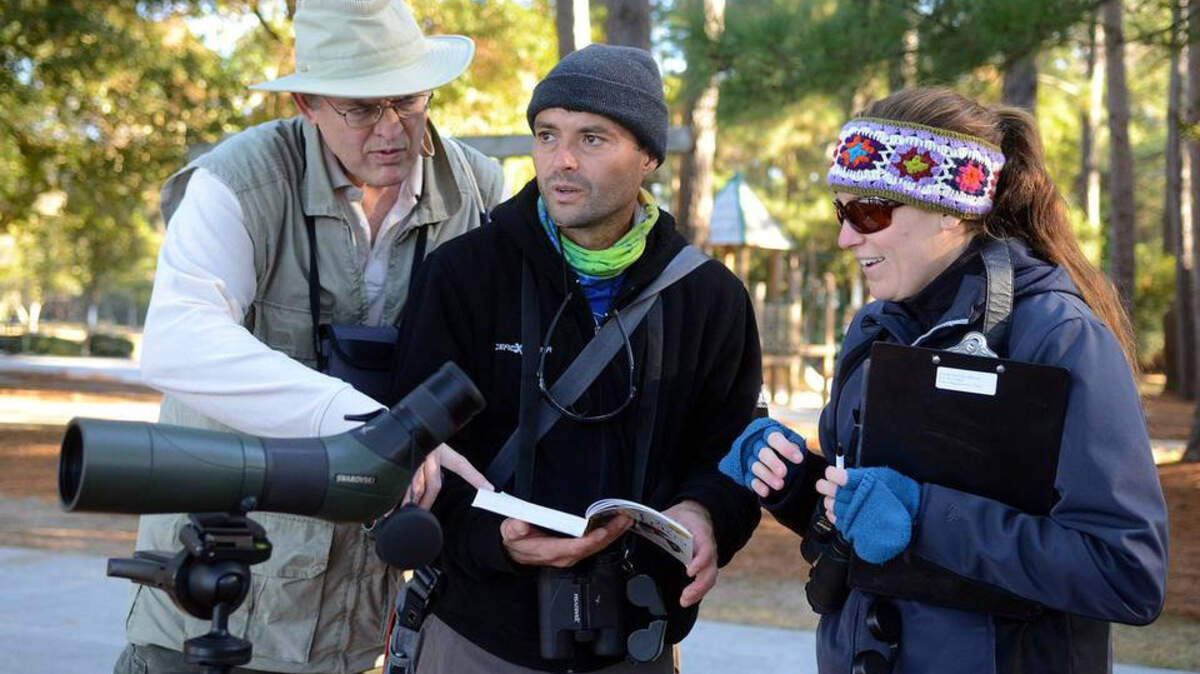 From left, Paul Weatherhead, Carlos Chacon and Dawn Brut check a reference book to identify a bird during the 2014 annual Christmas Bird Count at Honey Horn on Hilton Head Island.