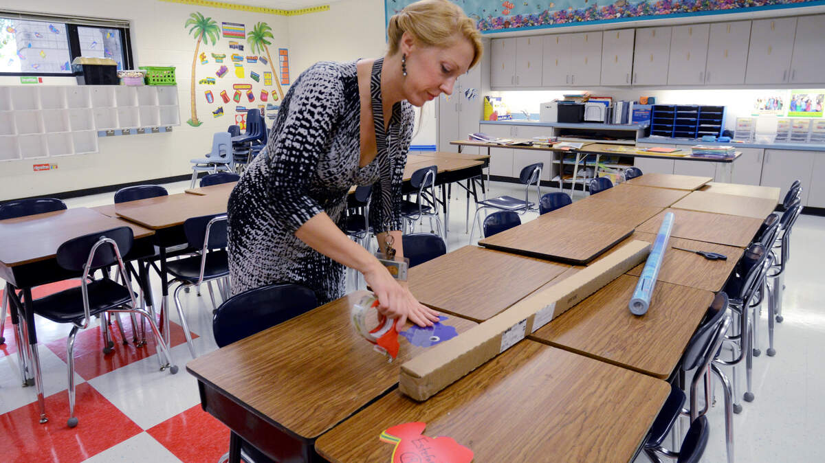 With the start of school less than a week away, fifth grade teacher Denise Schnurr was busy on Tuesday getting her classroom at Hilton Head Island Elementary School ready for the coming school year. Here, she tapes name labels to desks. The first day of school for the Beaufort County School District is Monday.