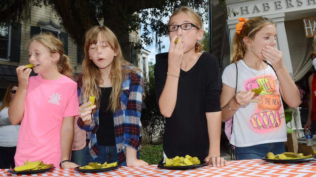 A group of youngsters struggles to eat plates full of pickles in a minute during a pickle eating competition at the Habersham Harvest Festival in Beaufort on Saturday. "It was really sour," said contestant Kailey Kreiss, 10, second from right.